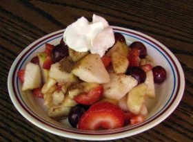 A cinnamon fruit plate with whipped cream.